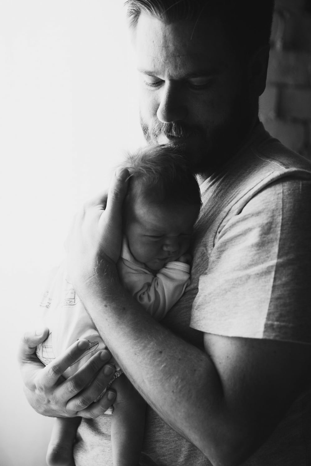 Dad holding newborn baby boy in black and white